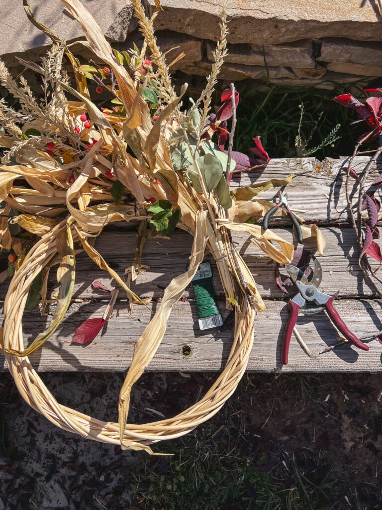 Wiring on corn husks to create a fall wreath