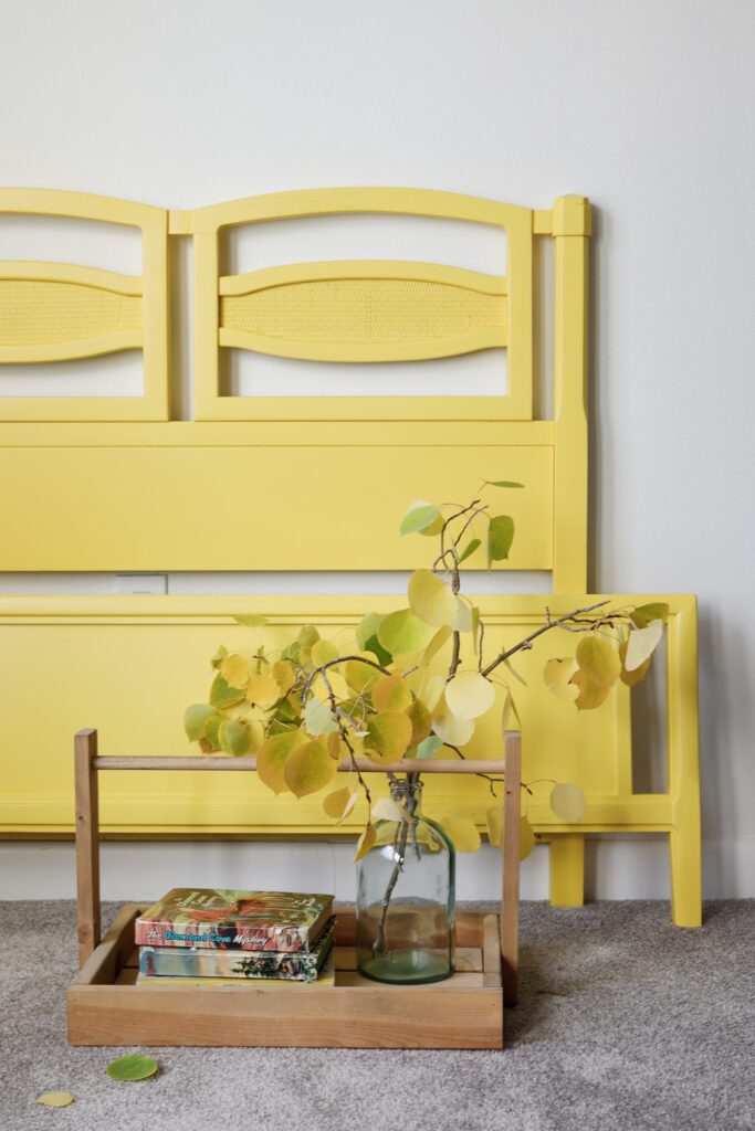 A yellow twin bed frame paired with a cute little wood tray