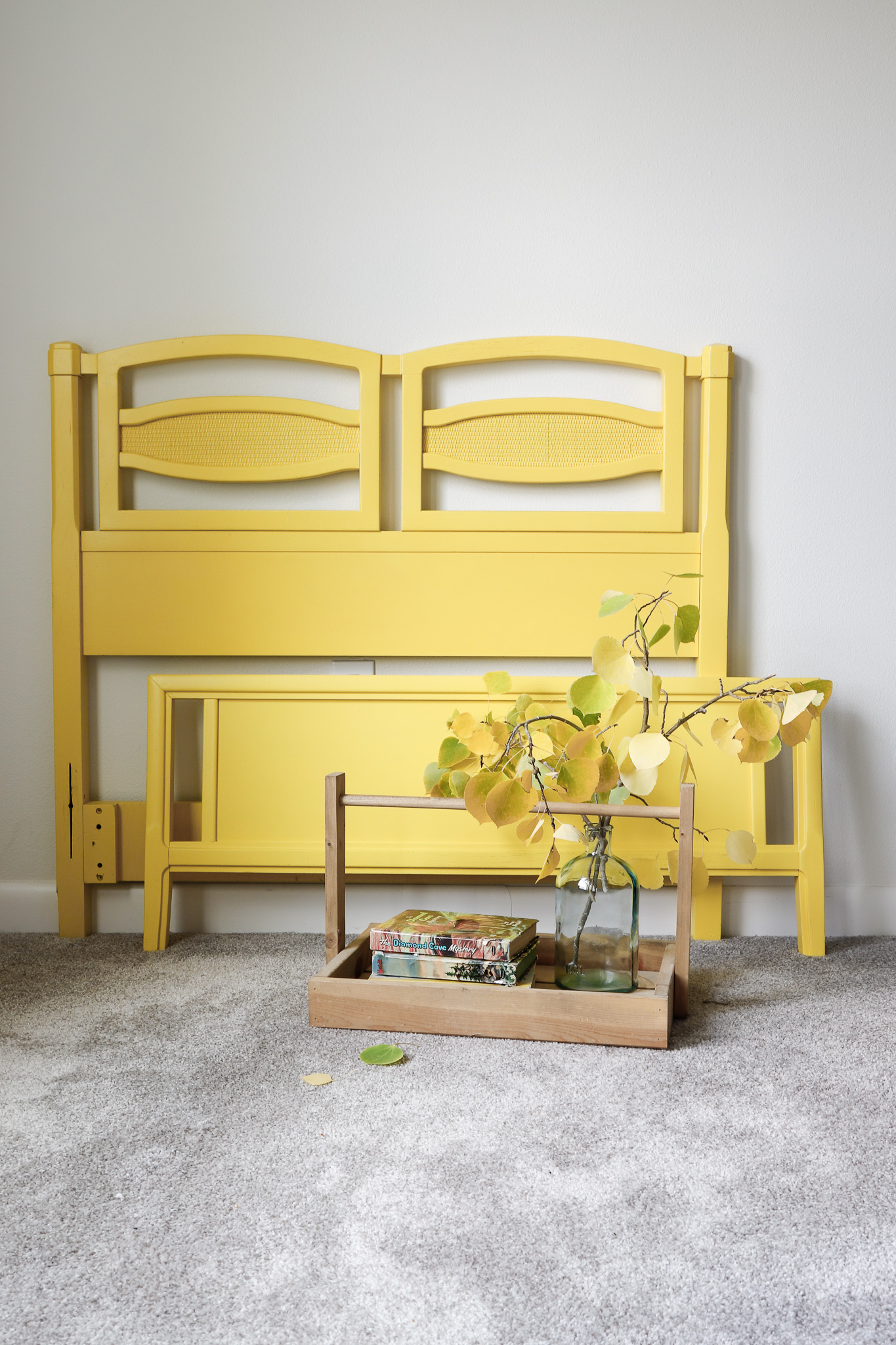 A darling vintage twin bed frame in a sunny yellow color